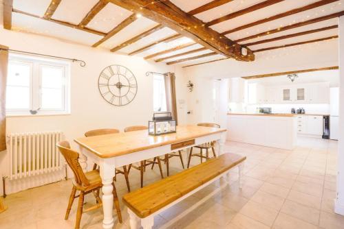 a kitchen and dining room with a table and chairs at The Old Coach house- a delightful home from home in Witney