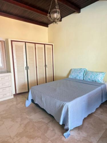 a bedroom with a bed with a blue bedspread at Maresia Beach House in Rio das Ostras