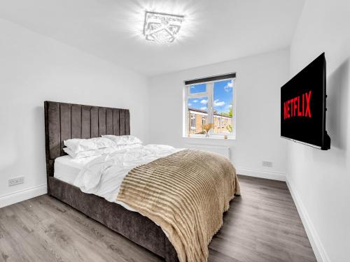 a white bedroom with a large bed and a window at LODGEselect in Thamesmead