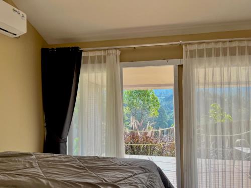 a bedroom with a bed and a large window at Cabin Inn by Batu Pineus in Pengalongan