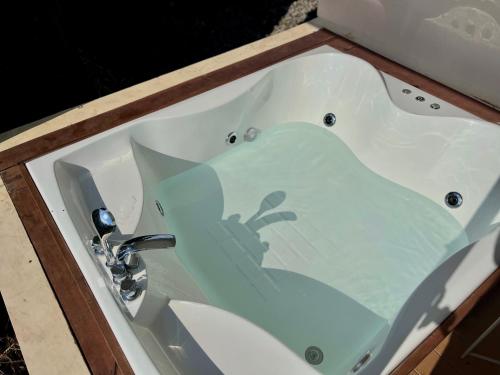 a bath tub with a sink in a bathroom at Cabin Inn by Batu Pineus in Pengalongan