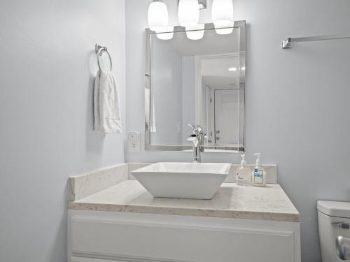 a white bathroom with a sink and a mirror at Oceanfront vacation home - EAST in Emerald Isle