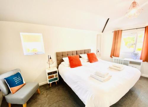 a bedroom with a large white bed and a chair at Mill View-an idyllic base to explore The Cotswolds in Northleach