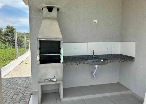 a kitchen with a sink and a stove at Flat em Varginha, Minas Gerais com Lazer Total e Estacionamento Gratuito in Varginha