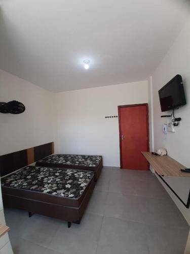 a bedroom with a bed and a red door at Flat em Varginha, Minas Gerais com Lazer Total e Estacionamento Gratuito in Varginha
