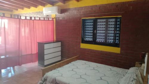a bedroom with a bed and a window and a dresser at Departamento Fede 1 in Carpintería