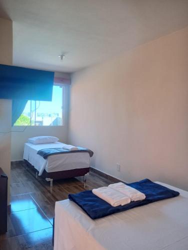 a room with two beds and a window at Pousada laranja in Xangri-lá