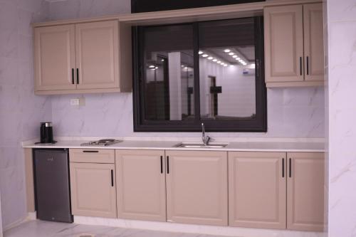 a kitchen with a sink and a mirror at شاليهات ذهب in Amman