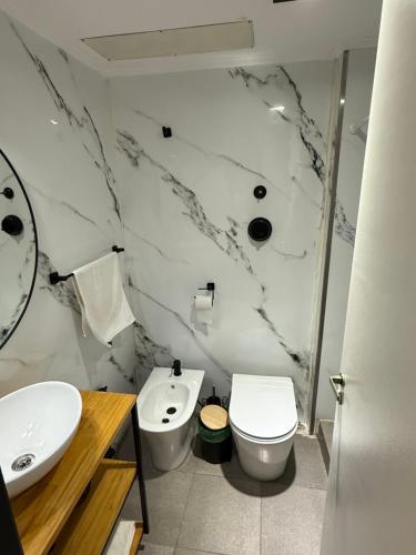 a white bathroom with a sink and a toilet at Studio Mirador in San Carlos de Bariloche