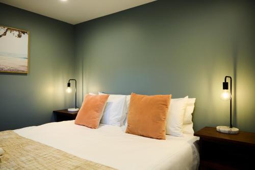 a bedroom with a bed with pillows and two lamps at Sunny Balcony | Mountain Views | Relaxed - KK04313 in Kaikoura