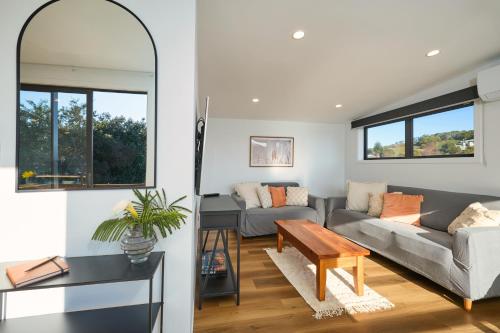 a living room with a couch and a table at Sunny Balcony | Mountain Views | Relaxed - KK04313 in Kaikoura