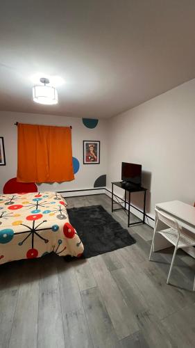 a bedroom with a bed and a desk with a laptop at Casa Pinturella in Silver Spring