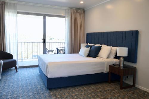 a bedroom with a large bed with a large window at Victory Hotel Motel Gympie in Gympie