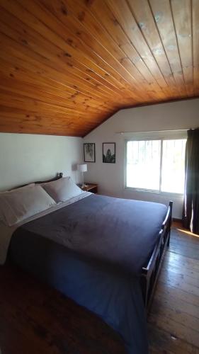 a large bed in a room with a wooden ceiling at Muelle los Indios in Tigre