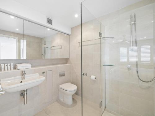 a bathroom with a shower and a toilet and a sink at Wharf Lodge River View Apartment in Maroochydore