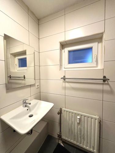a white bathroom with a sink and a mirror at modernes gemütliches Apartment in Gießen