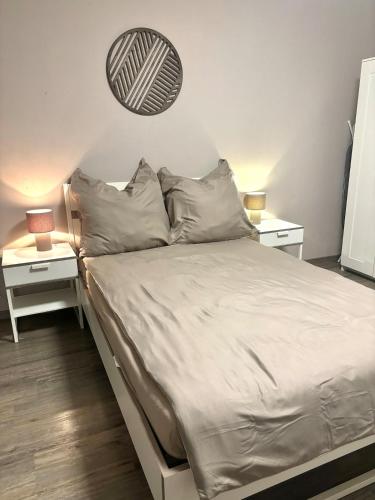 a bed with white sheets and pillows in a bedroom at modernes gemütliches Apartment in Gießen