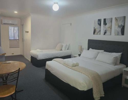a hotel room with two beds and a table at Flaxton Country Lodge in Flaxton