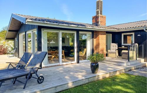a deck with a rocking chair on a house at Awesome Home In Haderslev With Wifi in Haderslev