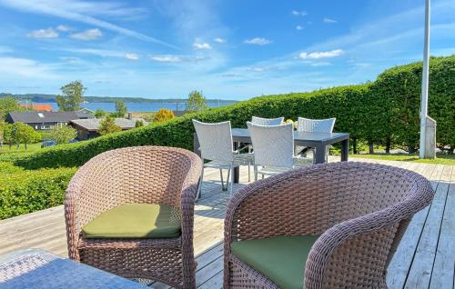 a patio with wicker chairs and a table on a deck at Nice Home In Børkop With Wifi in Børkop