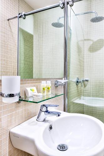 a bathroom with a sink and a glass shower at Hotel Palmeras De Luz in Moniquirá