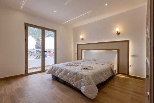 a bedroom with a large bed and a large window at Taghazout Waves Surf camp & Hotel in Aourir
