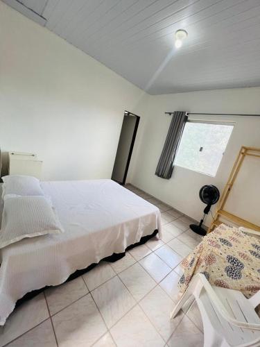 a bedroom with a white bed and a window at Suite Aconchegante com ampla Area externa - Green in São Luís