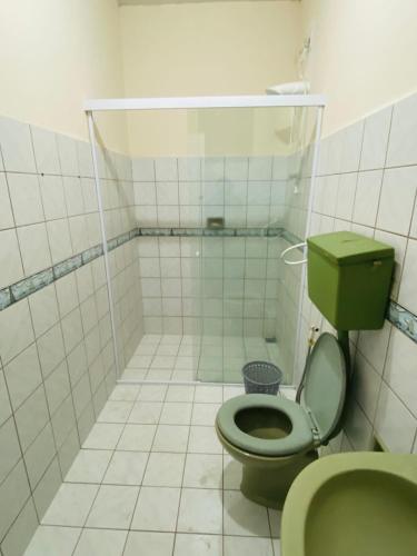 a bathroom with a green toilet and a shower at Suite Aconchegante com ampla Area externa - Green in São Luís