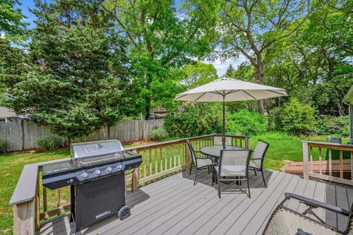 a deck with a grill and a table and an umbrella at Cozy Cape Escape Near Beaches Dining in Centerville