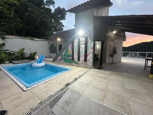 a house with a swimming pool in the yard at Coffehouse - Casa com Piscina in São Vicente