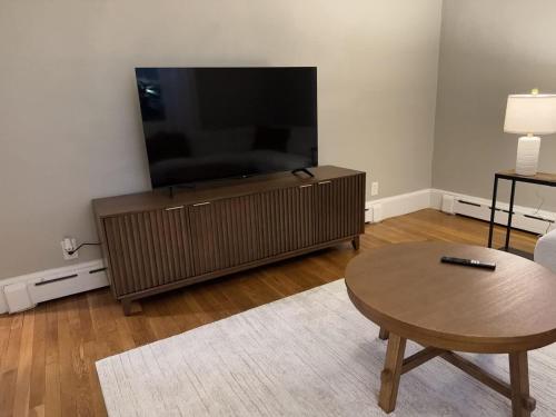 a living room with a flat screen tv and a coffee table at Comfortable 4 Bed Home close to Gillette in Foxborough