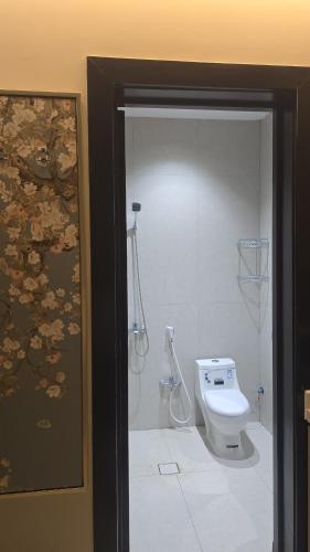 a bathroom with a white toilet and a shower at نُزل البدر - غرفة و صالة دخول ذاتي in Al Kharj