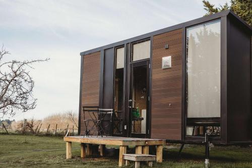 a tiny house sitting on top of a bench at Matariki Akura by Tiny Away in Masterton