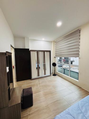 a living room with a large window and a television at May Ong Guest House in Taiping