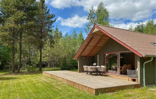 a wooden deck next to a house with a table at Beautiful Home In Ans By in Roe
