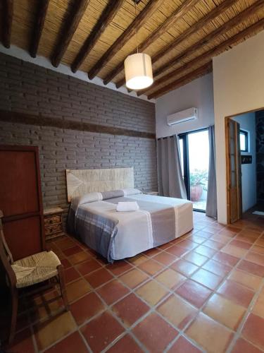 a bedroom with a large bed in a brick wall at Posada Santa Isabel in Parras de la Fuente