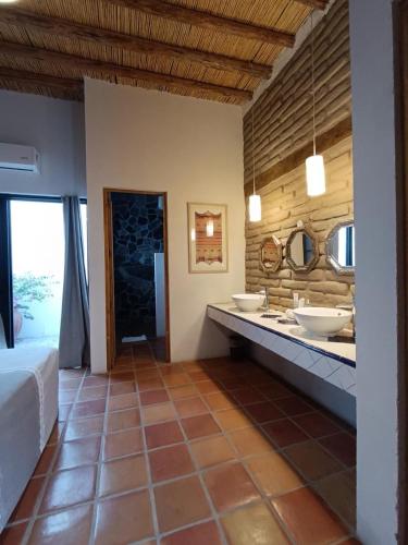 a bathroom with two sinks and two mirrors at Posada Santa Isabel in Parras de la Fuente