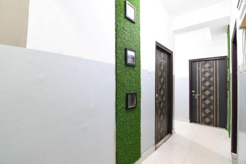 a hallway with two doors and green grass at OYO 82026 BANGUR INN in Nager Bazaar