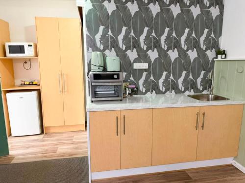 a kitchen with a sink and a refrigerator at Barossa Palms Motel in Nuriootpa