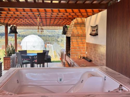 a large bath tub in a kitchen with a patio at La Cabaña de Ciela C glamping con jacuzzi , minigolf y croquet in Latacunga