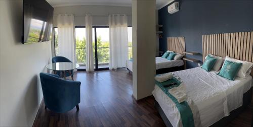 a bedroom with a bed and a table and a chair at Central Suites in Tarapoto