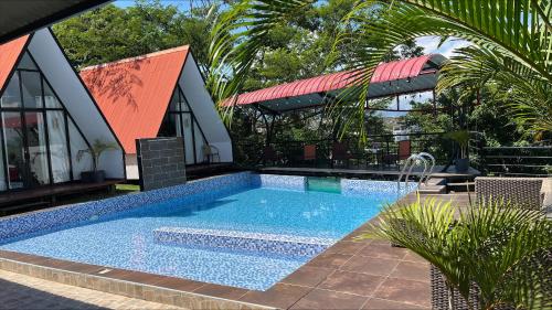 a swimming pool in front of a building with a house at Central Suites in Tarapoto