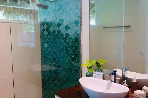 a bathroom with a sink and a glass shower at The Shacks at Sandy Bay in Nusa Lembongan