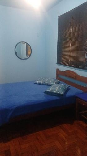 a bedroom with a bed with a mirror on the wall at Hotel Flamingos in Santos