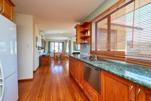 a kitchen with wooden cabinets and a counter top at Coastal, Spacious, Mountain Views - KK21238 in Kaikoura