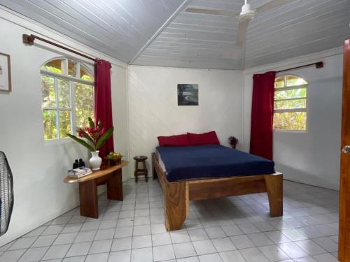a bedroom with a bed and two windows at Cozy cabin by the sea in Cahuita