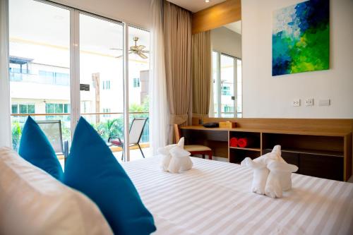 two stuffed animals sitting on a bed in a room at Krabi One Bedroom Pool View in Klong Muang Beach