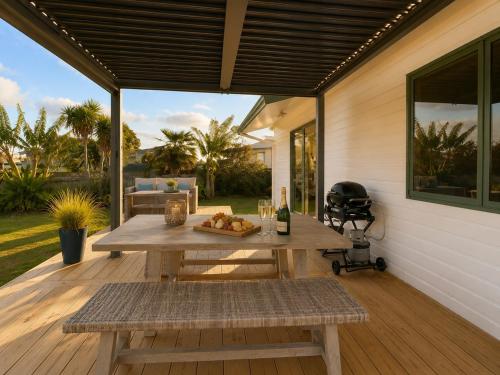 a patio with a picnic table and a grill at Hosts on the Coast Make Memories on Cook in Whitianga