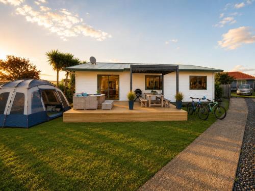 a house with a tent in the yard at Hosts on the Coast Make Memories on Cook in Whitianga