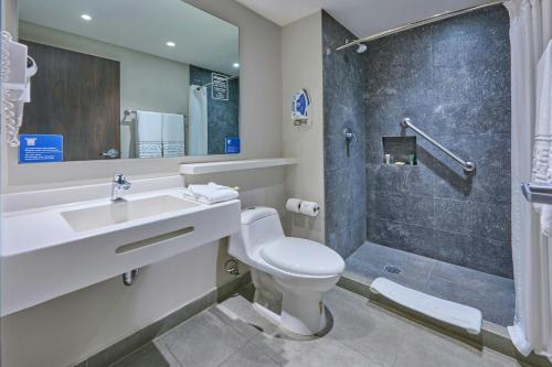 a bathroom with a toilet and a sink and a shower at City Express by Marriott Lagos de Moreno in Lagos de Moreno
